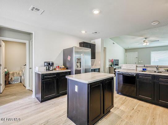 kitchen with a sink, visible vents, dark cabinetry, stainless steel refrigerator with ice dispenser, and dishwasher