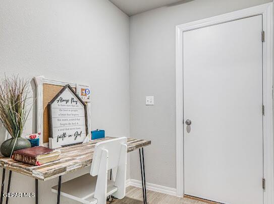 home office featuring baseboards and wood finished floors