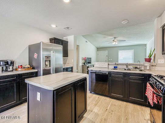 kitchen with black appliances, light wood-type flooring, a sink, and light countertops