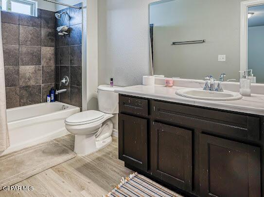 bathroom featuring shower / tub combination, vanity, toilet, and wood finished floors