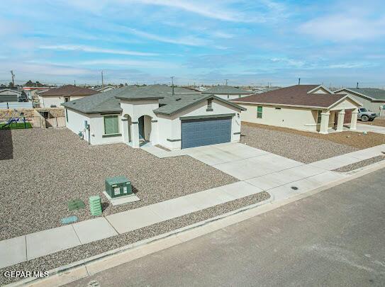 view of front of property featuring a garage, a residential view, and driveway