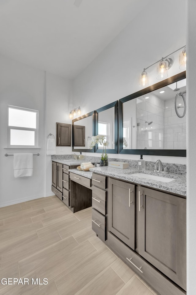 bathroom featuring double vanity, a stall shower, a wealth of natural light, and wood tiled floor