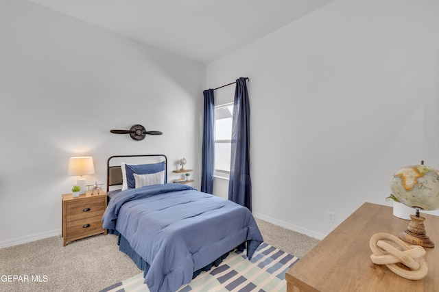 bedroom with baseboards and light colored carpet