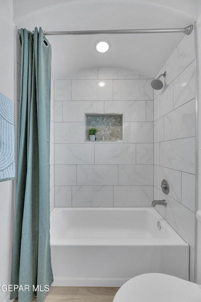 full bathroom featuring toilet, shower / bath combo, and wood finished floors