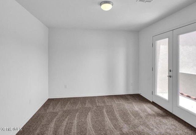 carpeted empty room with visible vents, baseboards, and french doors