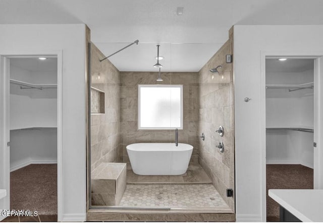 full bath featuring a stall shower and a freestanding bath