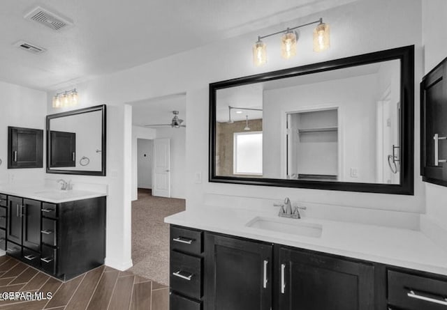 bathroom featuring two vanities, visible vents, and a sink