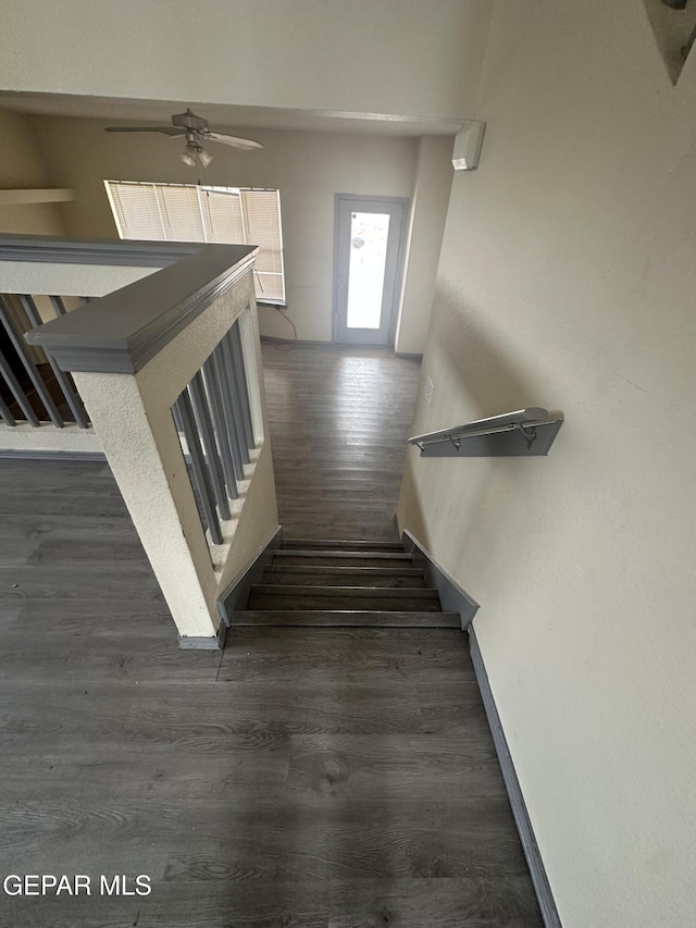 stairway with wood finished floors and baseboards