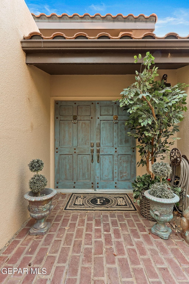 view of exterior entry with stucco siding