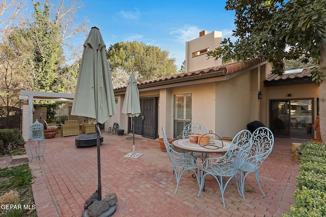 view of patio with an outdoor fire pit and fence