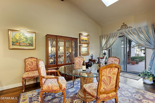 dining room with high vaulted ceiling, a skylight, wood finished floors, and baseboards