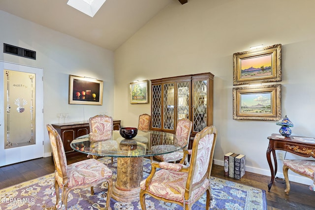 dining room featuring a skylight, baseboards, visible vents, wood finished floors, and high vaulted ceiling