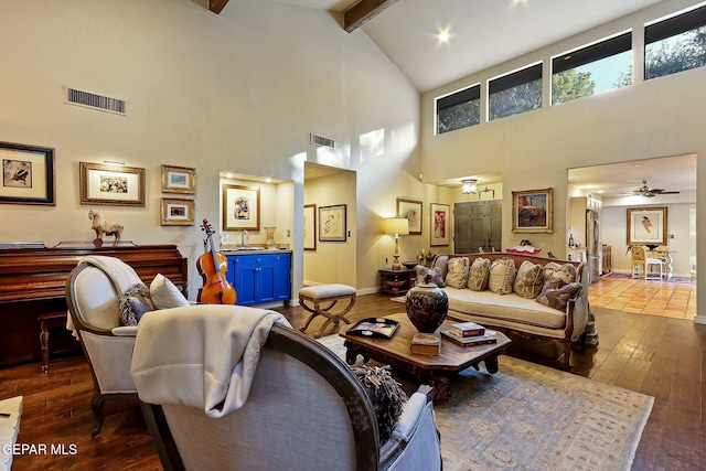 living area with dark wood-type flooring, visible vents, lofted ceiling with beams, and baseboards