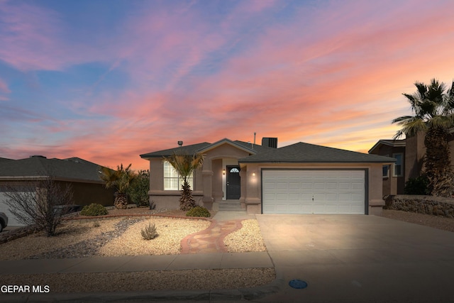 view of front of home featuring a garage, driveway, and stucco siding