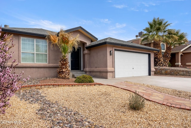 view of front facade featuring an attached garage, concrete driveway, and stucco siding