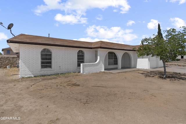 view of front of house featuring a garage, concrete driveway, and brick siding