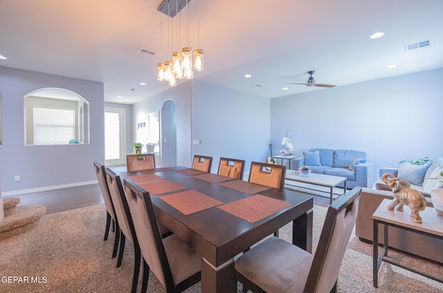 dining space with baseboards, visible vents, arched walkways, and recessed lighting