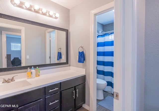 bathroom with toilet, curtained shower, and vanity