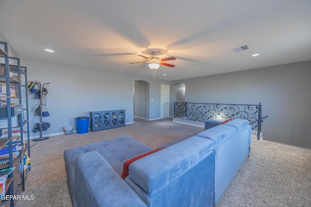 carpeted living room featuring arched walkways, recessed lighting, visible vents, ceiling fan, and baseboards