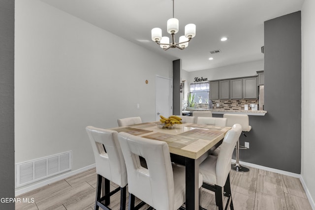 dining area with a chandelier, visible vents, and baseboards