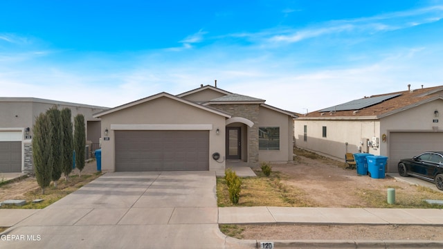 single story home with concrete driveway, stone siding, an attached garage, and stucco siding