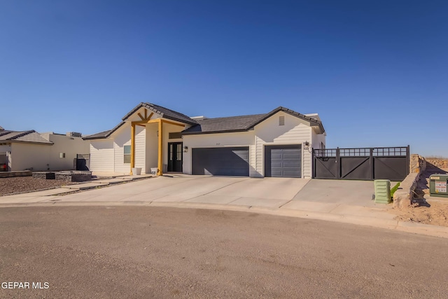 view of front of house featuring an attached garage, concrete driveway, and a tiled roof