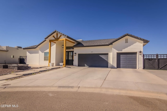 view of front facade featuring a garage, concrete driveway, and a tile roof