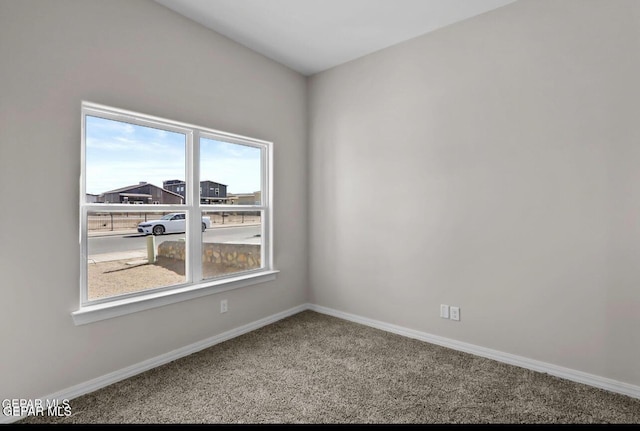 unfurnished room featuring carpet floors and baseboards