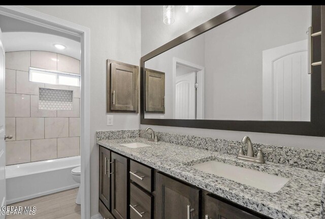 3869 Bubble, El Paso, TX 79938 - full bath featuring double vanity, toilet, a sink, and wood finished floors