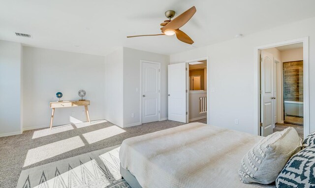 carpeted bedroom featuring a ceiling fan, connected bathroom, visible vents, and baseboards