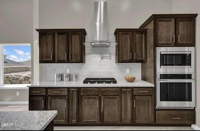 3864 Aspiration St, El Paso, TX 79938 - kitchen with dark brown cabinets, appliances with stainless steel finishes, wall chimney exhaust hood, and tasteful backsplash