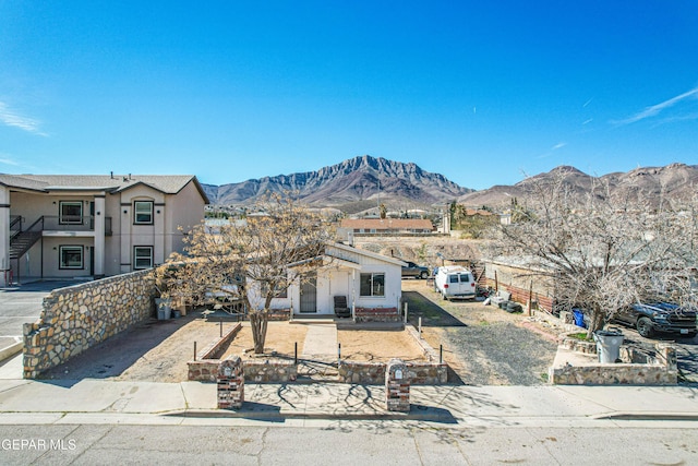 view of front of house featuring a mountain view, stairway, and fence