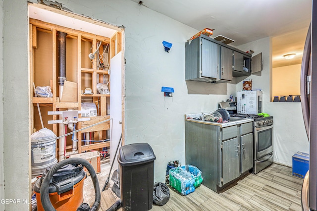 kitchen featuring gray cabinetry, stainless steel range with gas stovetop, and light wood-style floors