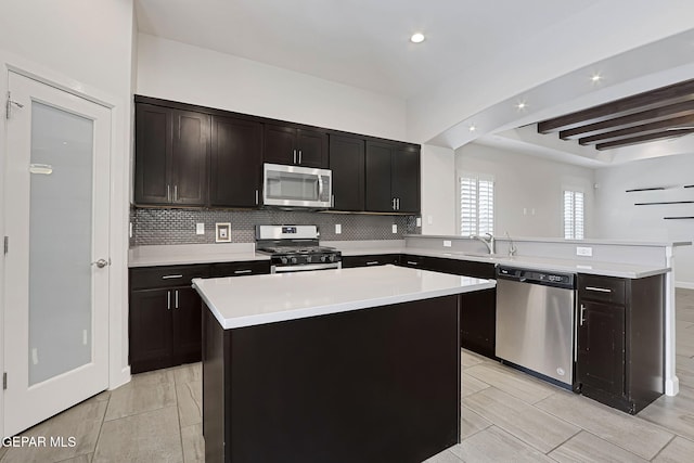 kitchen with a peninsula, backsplash, stainless steel appliances, and light countertops