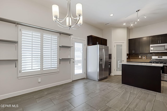 kitchen featuring dark brown cabinets, appliances with stainless steel finishes, hanging light fixtures, light countertops, and decorative backsplash