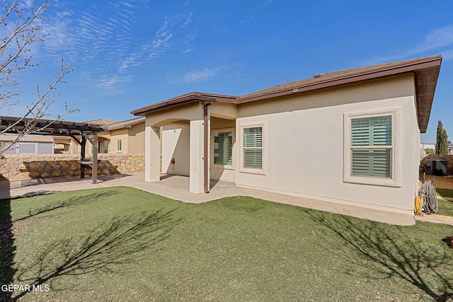 back of property with a yard, a pergola, a patio, and stucco siding