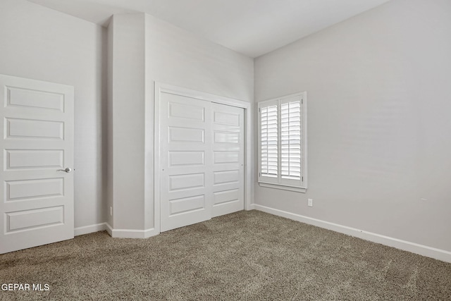 unfurnished bedroom featuring a closet, carpet flooring, and baseboards