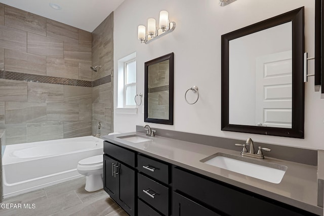 bathroom featuring shower / bathtub combination, double vanity, a sink, and toilet