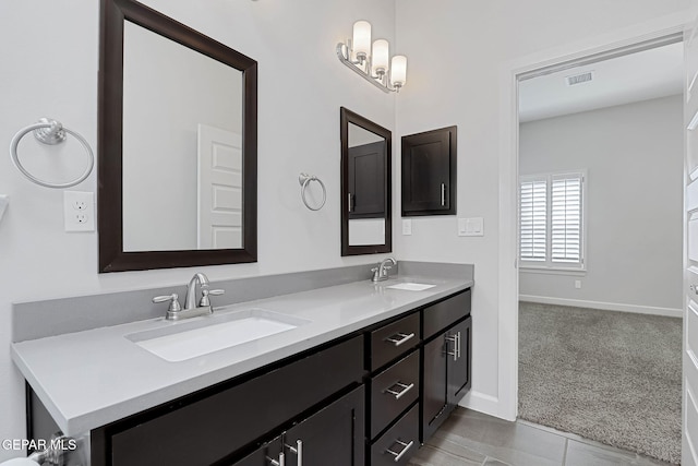 full bathroom with double vanity, a sink, visible vents, and baseboards