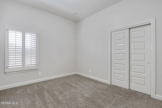 unfurnished bedroom featuring carpet floors, a closet, visible vents, and baseboards