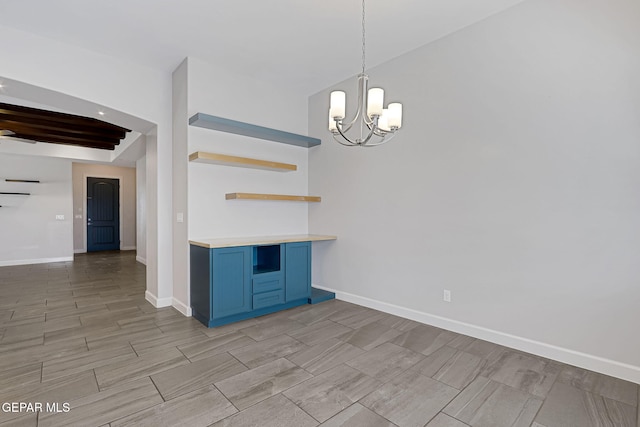 kitchen with baseboards, light countertops, blue cabinetry, open shelves, and an inviting chandelier