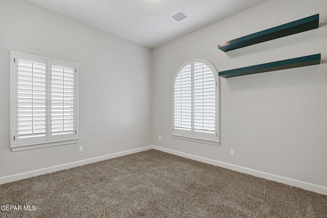 unfurnished room featuring carpet, visible vents, and baseboards