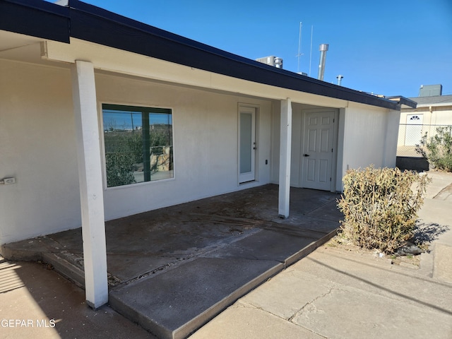 view of exterior entry with stucco siding