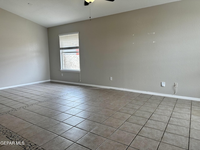 empty room featuring a ceiling fan, baseboards, and light tile patterned floors