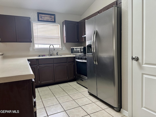 kitchen featuring stainless steel appliances, light countertops, light tile patterned flooring, and a sink