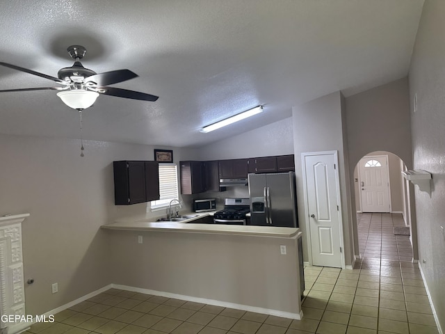 kitchen featuring lofted ceiling, under cabinet range hood, stainless steel appliances, a peninsula, and light countertops