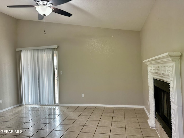 unfurnished living room featuring a ceiling fan, a brick fireplace, baseboards, and light tile patterned floors