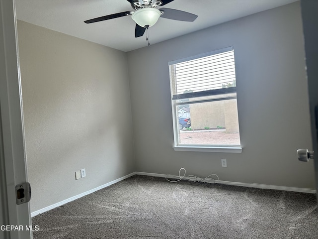 empty room with carpet flooring, a ceiling fan, and baseboards