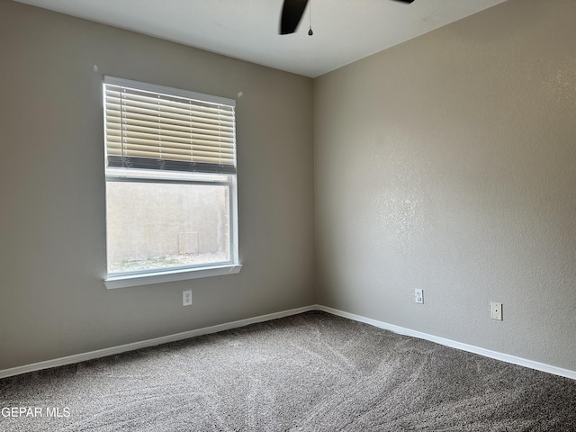 carpeted spare room with ceiling fan and baseboards