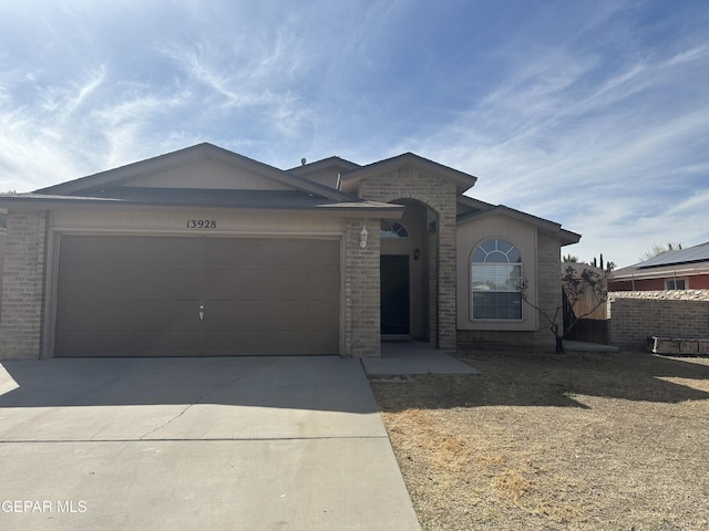 ranch-style house featuring a garage, concrete driveway, and brick siding